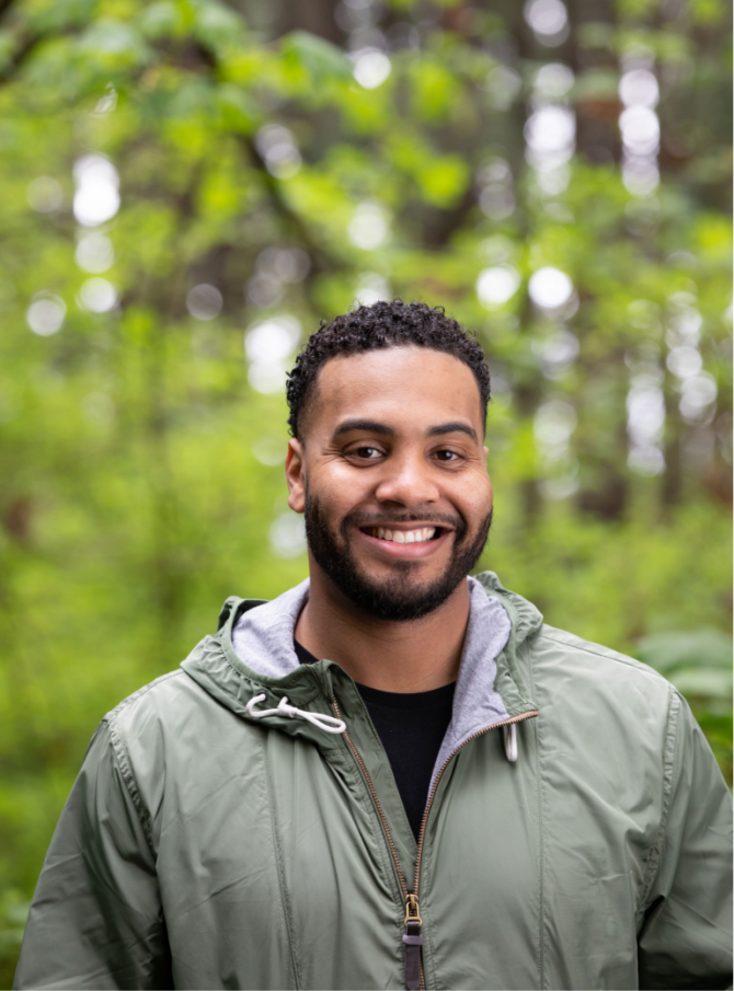 Closeup of person in forest smiling and looking at camera